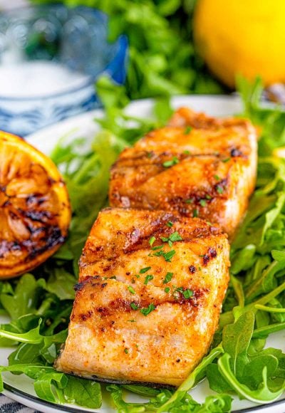 Close up photo of grilled mahi mahi on a bed of greens.