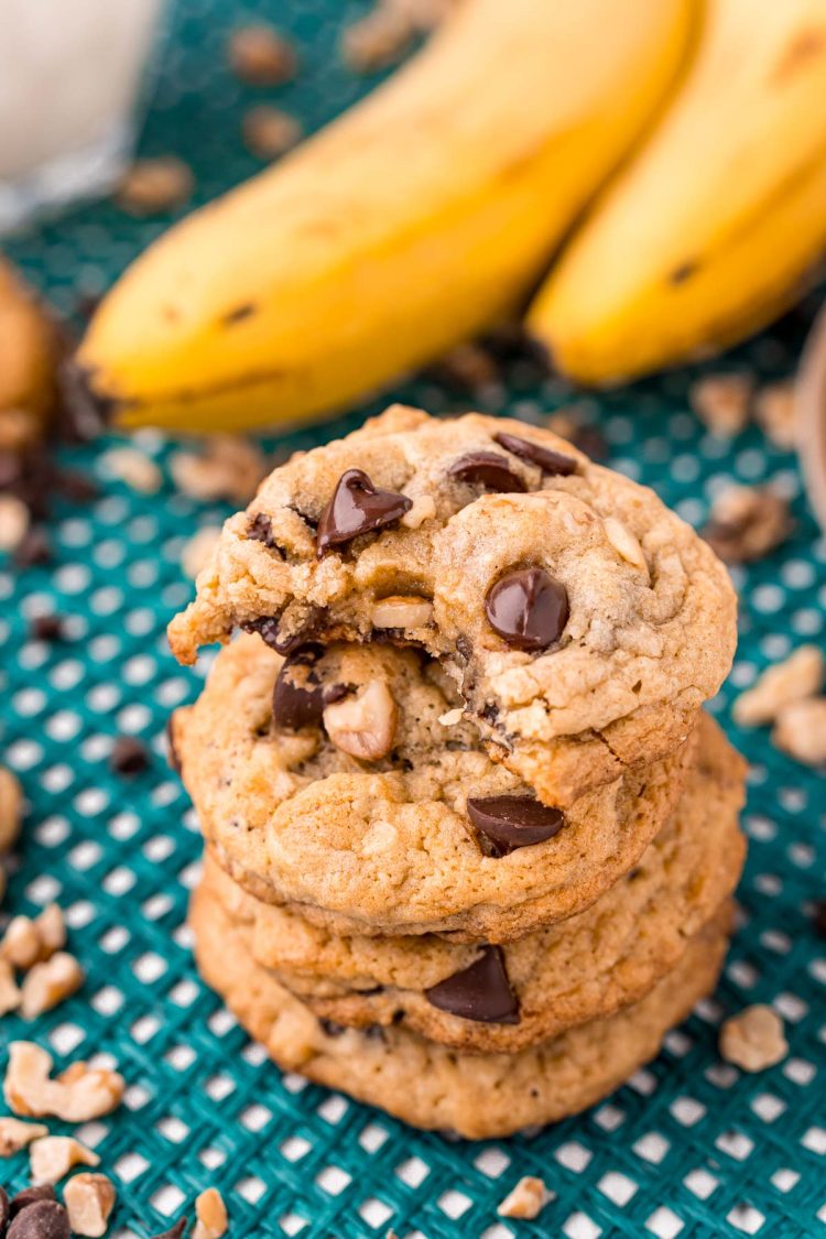 Close up photo of a stack of four banana bread cookies with the top one missing a bite.