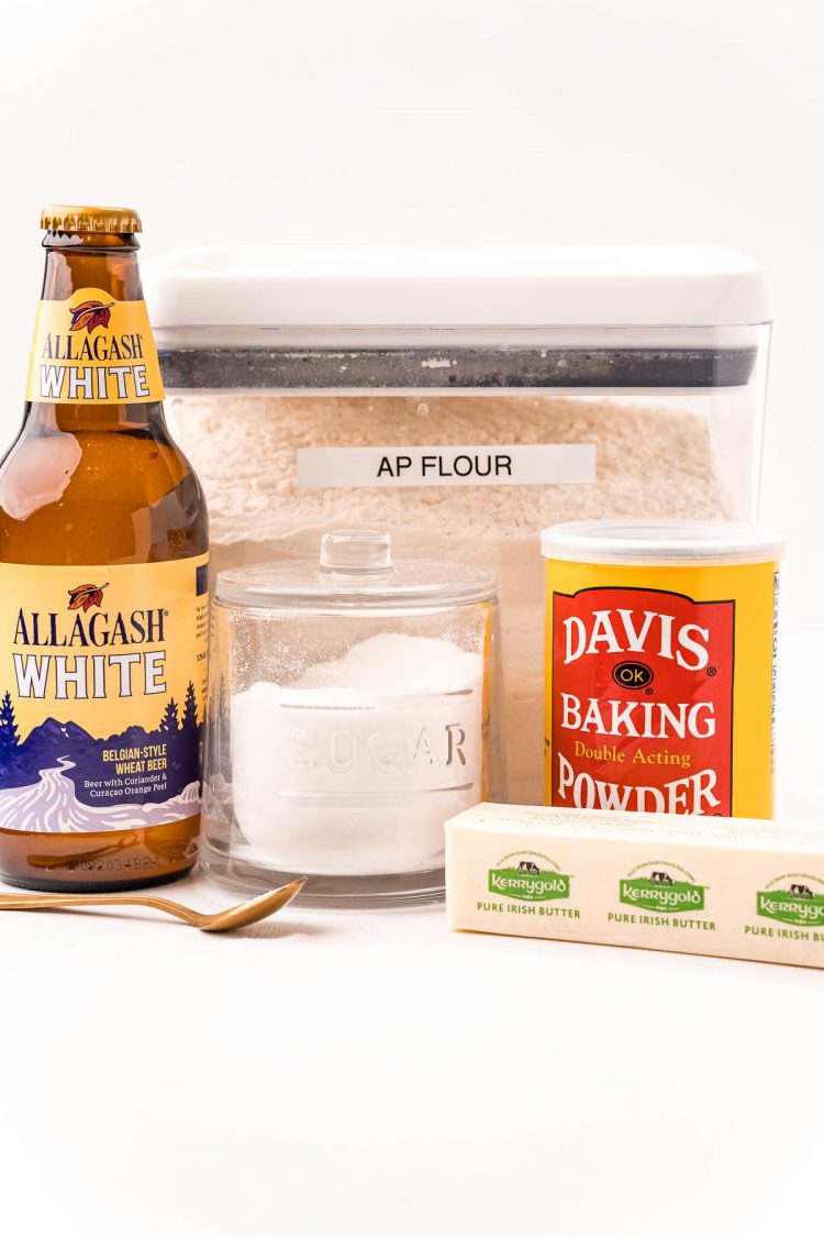 Ingredients to make beer bread on a white table.