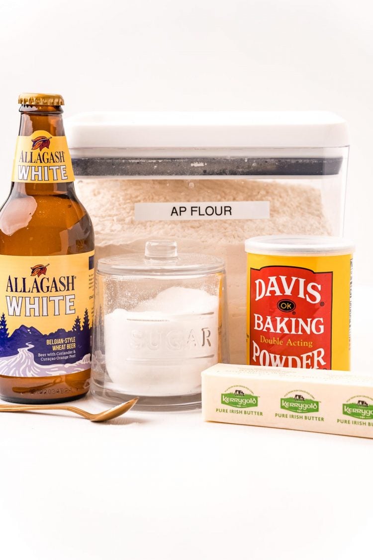 Ingredients to make beer bread on a white table.