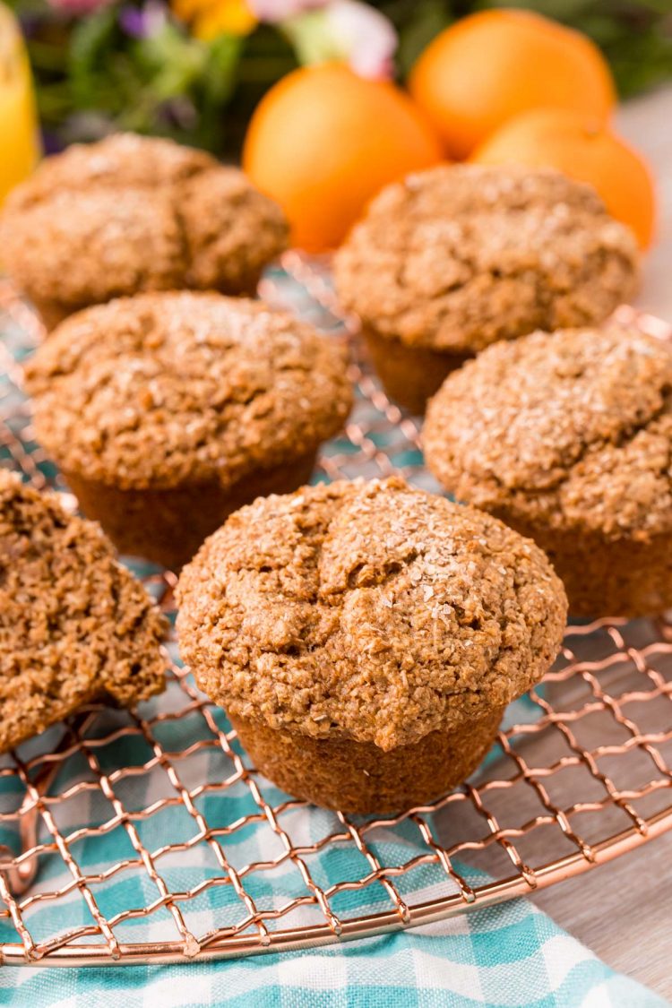 Bran muffins on a copper wire rack.