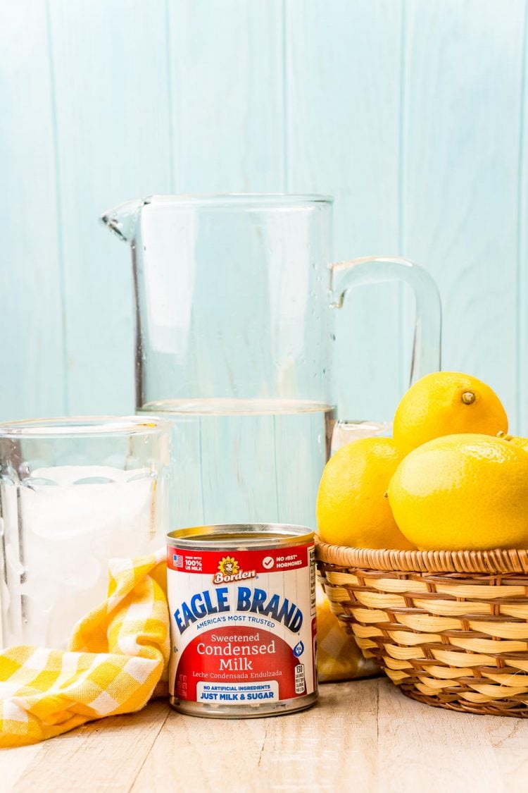 Ingredients to make creamy lemonade on a wooden counter.