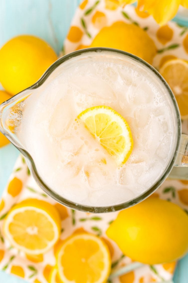 Overhead photo of a pitcher of creamy lemonade surrounded by lemons.