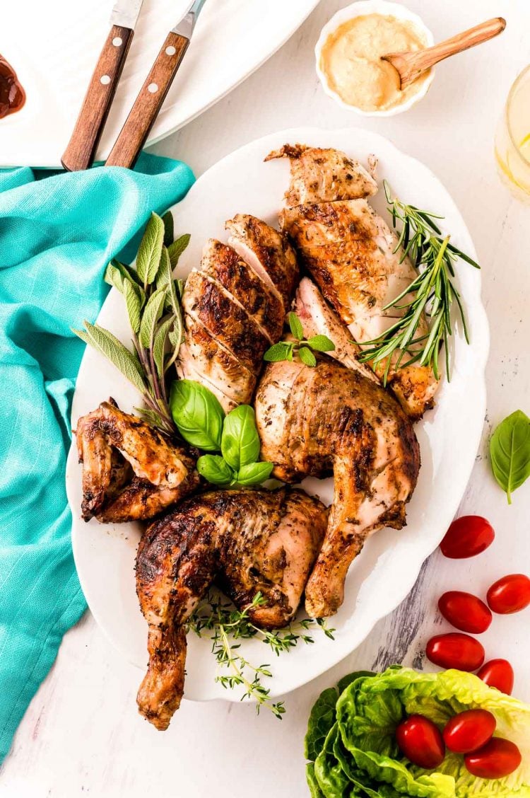 Overhead photo of a spatchcock grilled chicken that has been broken down and plated on a serving platter.