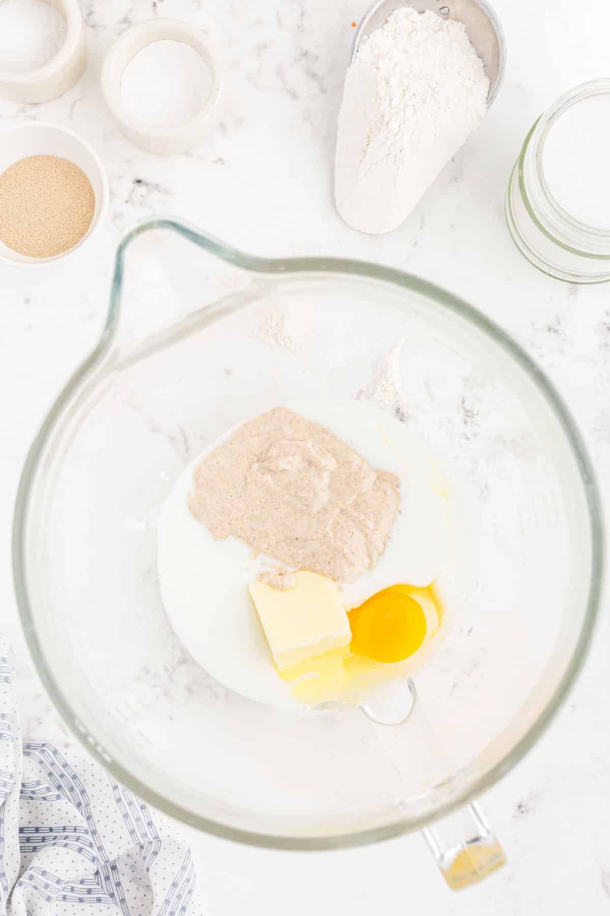 Buttermilk, butter, egg, and yeast in a mixing bowl.