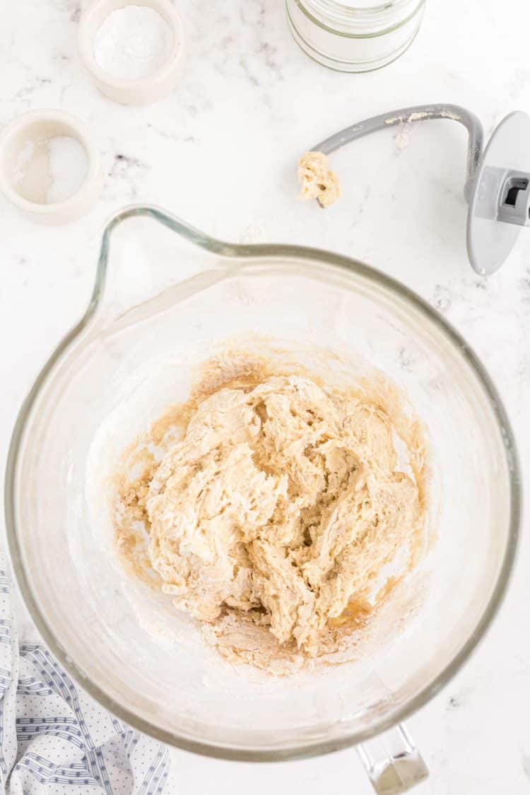 Dough for dinner rolls being made in a mixing bowl.