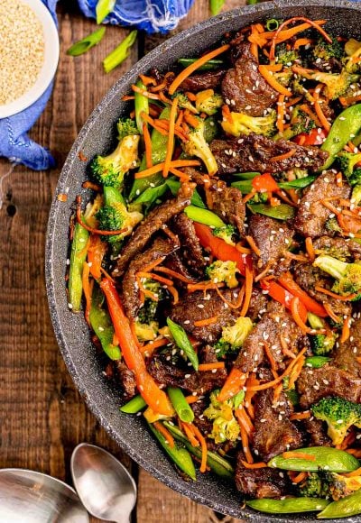 Beef stir fry in a pan on a wooden table.