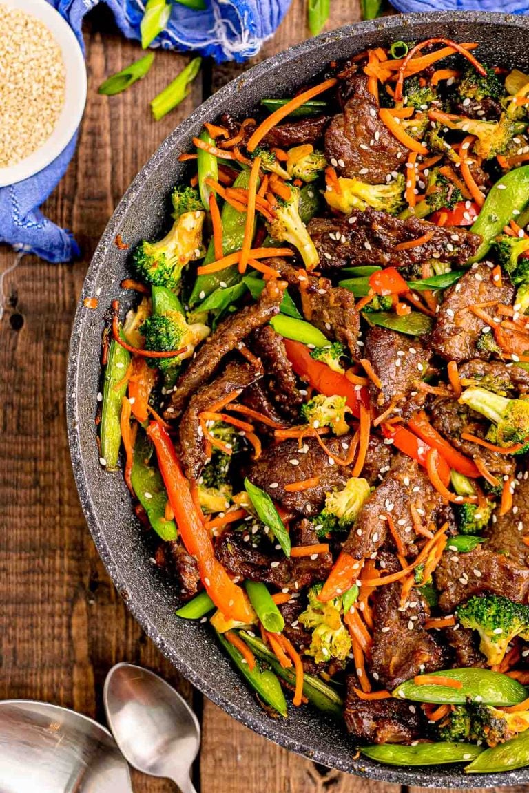 Beef stir fry in a pan on a wooden table.