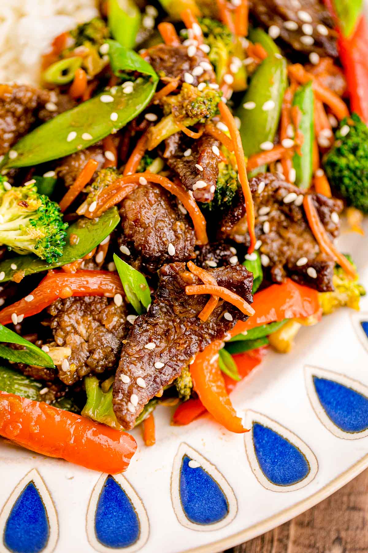 Close up of beef stir fry in a white and blue bowl.