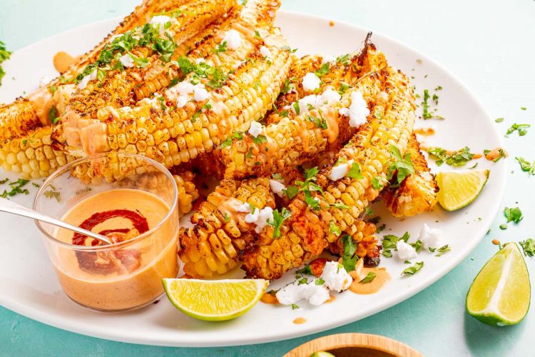 Close up photo of corn ribs on a white plate.