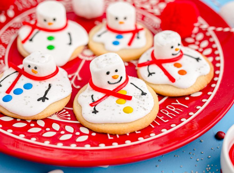 A red plate with melted snowman cookies on it.