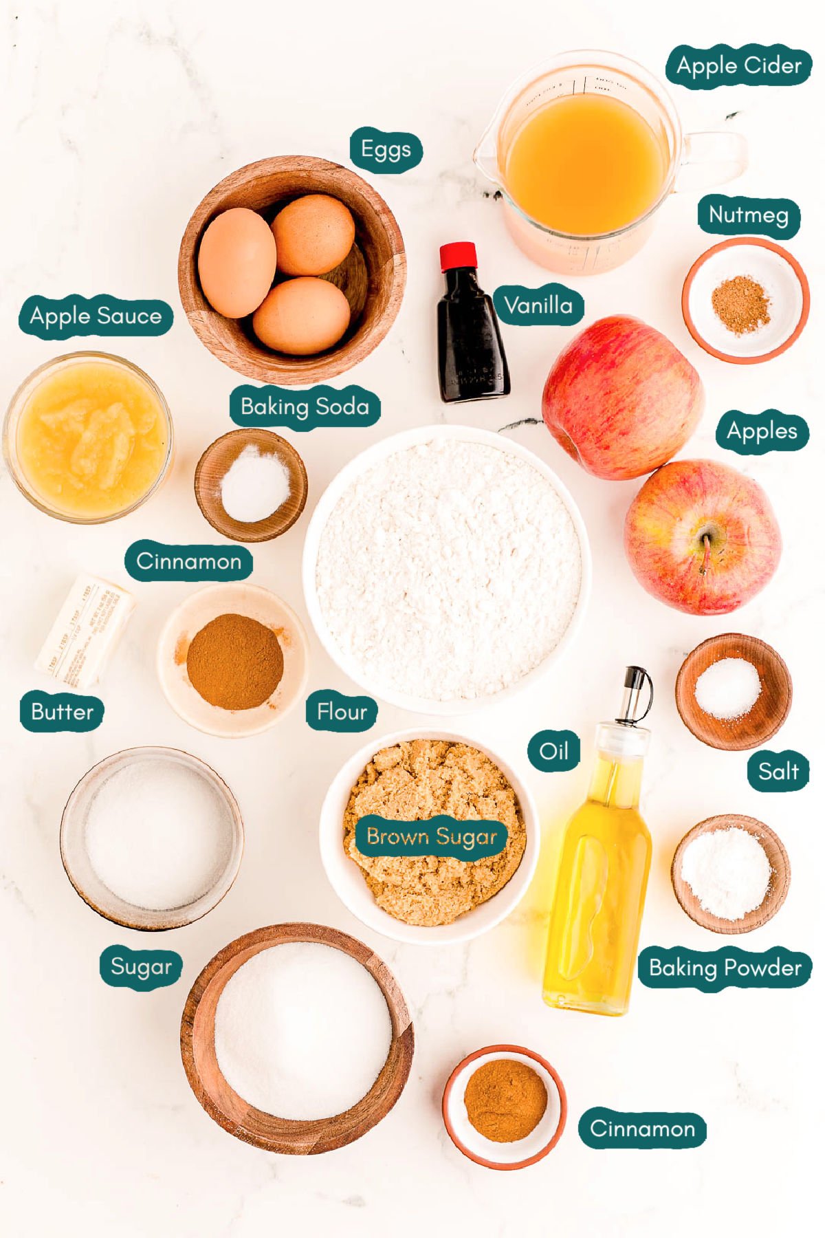 Overhead photo of ingredients to prepare apple cider donut cake on a marble surface.