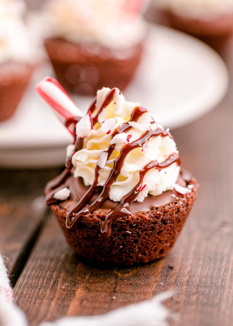 Close up photo of hot chocolate brownie cups on a wooden table.