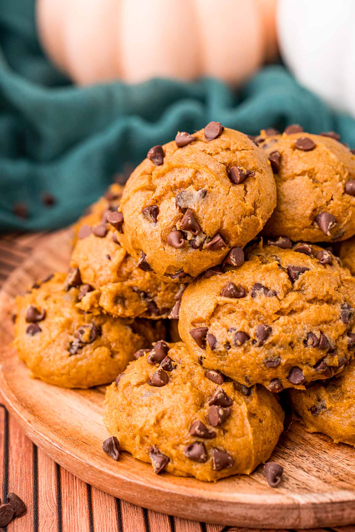 Pumpkin chocolate chip cookies on a wooden plate.