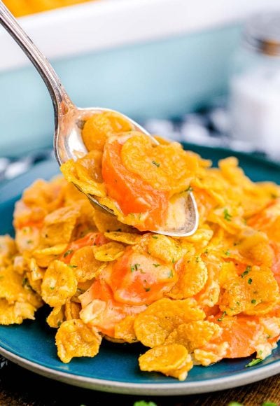 Close up photo of carrot casserole being scooped onto a blue plate.