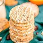 Close up photo of a stack of cranberry orange shortbread cookies on a teal napkin.