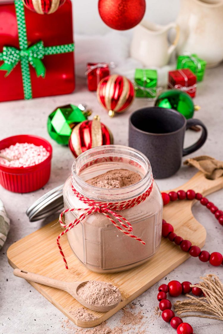 Close up photo of a jar with homemade hot chocolate mix in it with a baking twine ribbon around the neck of the jar.