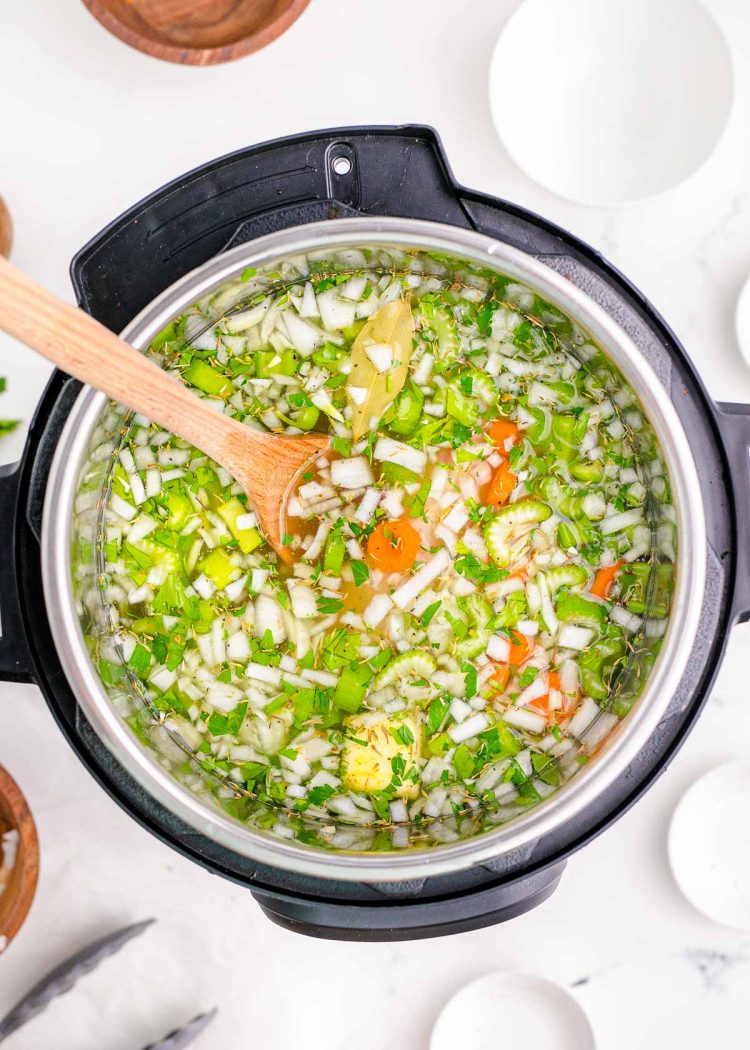 Ingredients added to an instant pot to make chicken noodle soup.