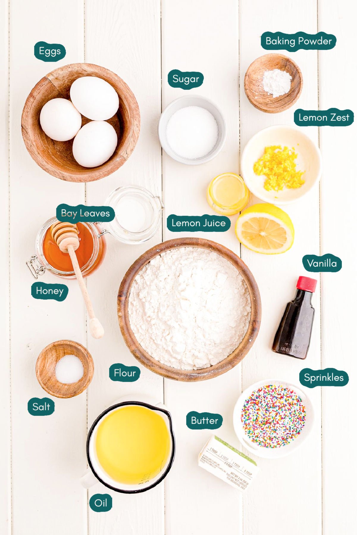 Overhead photo of ingredients to make struffoli on a white wooden table.