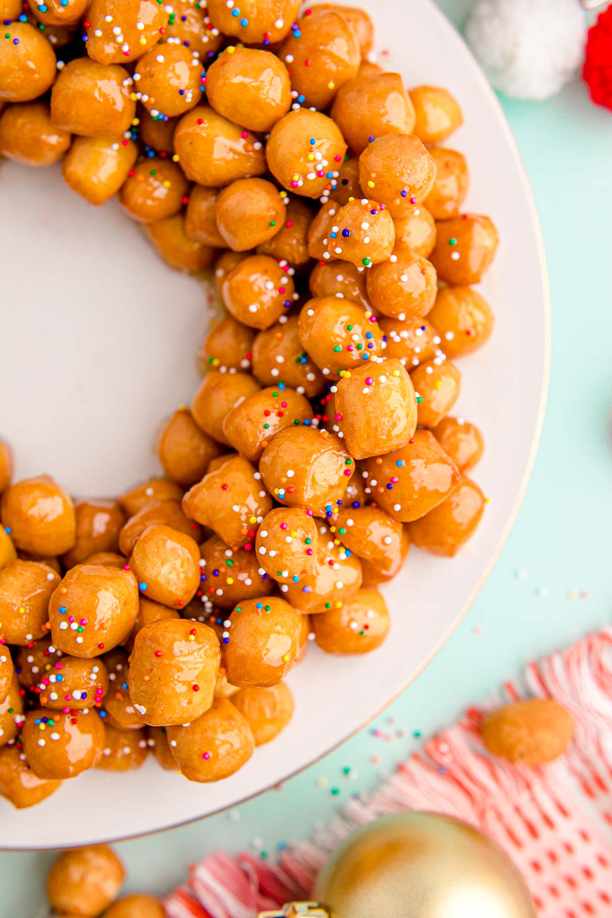 Close up photo of struffoli on a white plate.