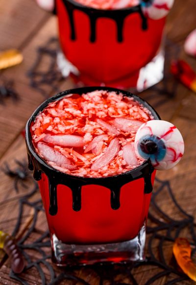 Close up photo of two glasses filled with werewolf Halloween punch on a wooden table.