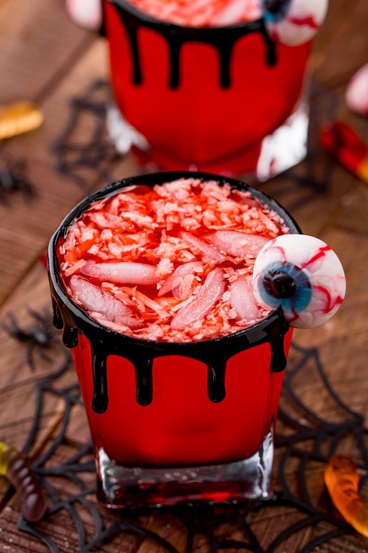 Close up photo of two glasses filled with werewolf Halloween punch on a wooden table.