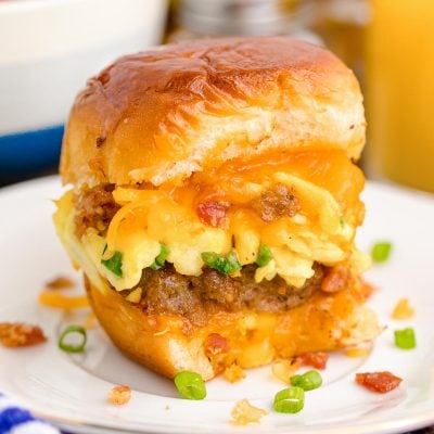 Close up photo of breakfast sliders on a white plate on a blue and white striped napkin.