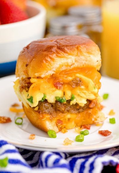 Close up photo of breakfast sliders on a white plate on a blue and white striped napkin.