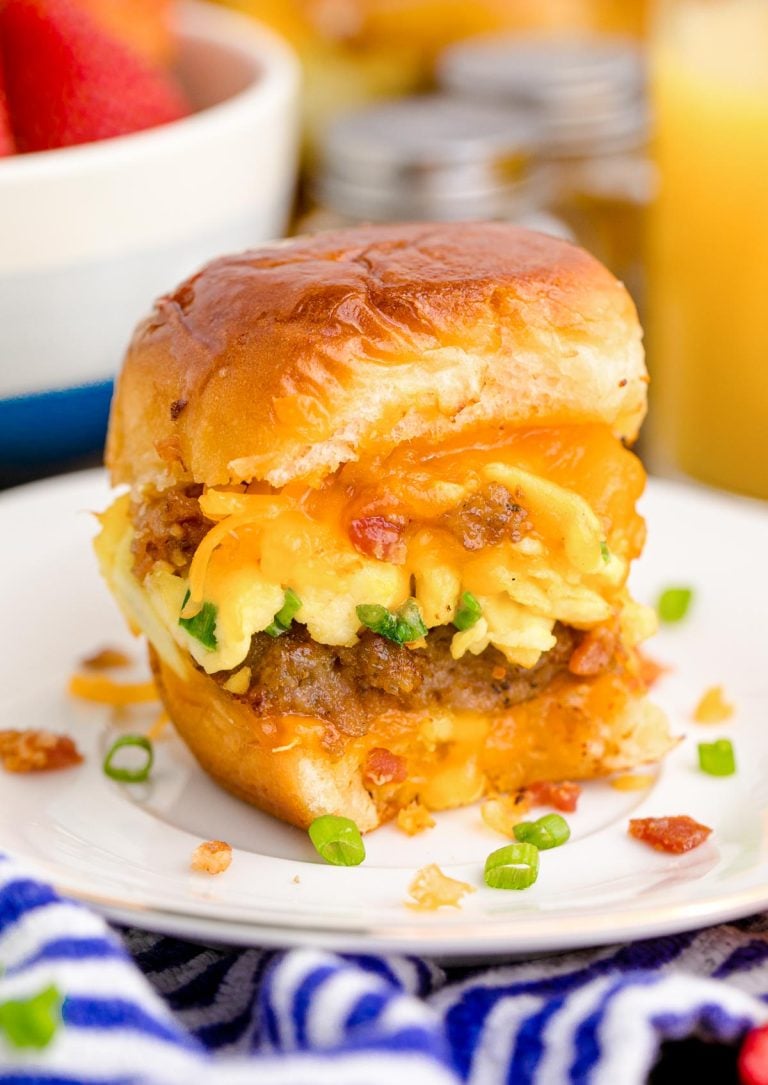 Close up photo of breakfast sliders on a white plate on a blue and white striped napkin.