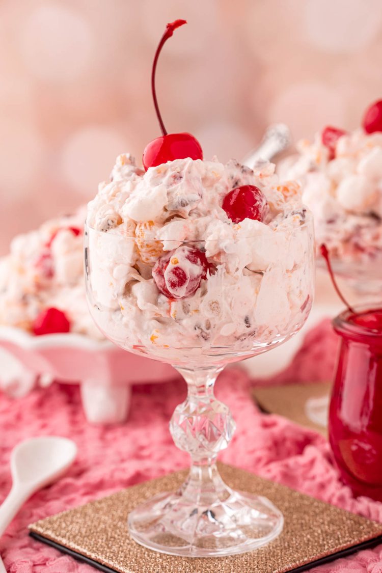 Close up photo of a glass serving dish with fruit ambrosia salad in it.