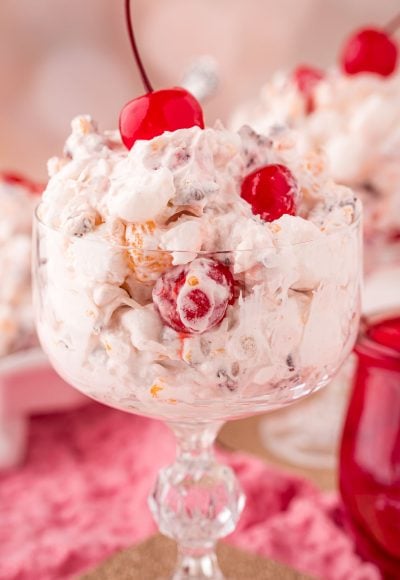 Close up photo of a glass serving dish with fruit ambrosia salad in it.