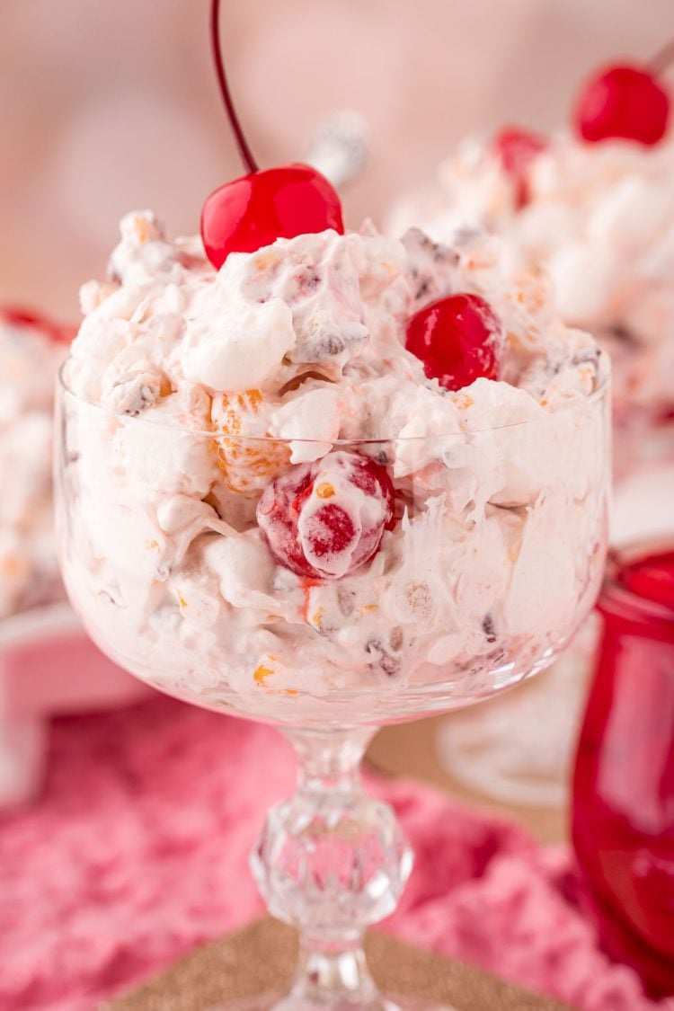 Close up photo of a glass serving dish with fruit ambrosia salad in it.