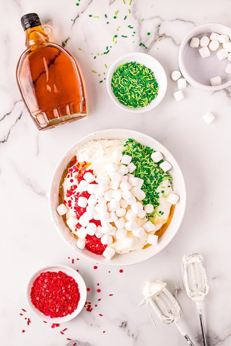 Overhead photo of a christmas dip being made in a white bowl on a marble surface.