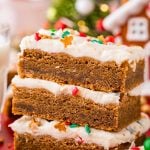 Close up photo of a stack of three gingerbread bars with cream cheese frosting.