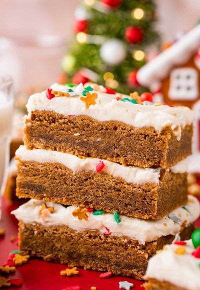 Close up photo of a stack of three gingerbread bars with cream cheese frosting.