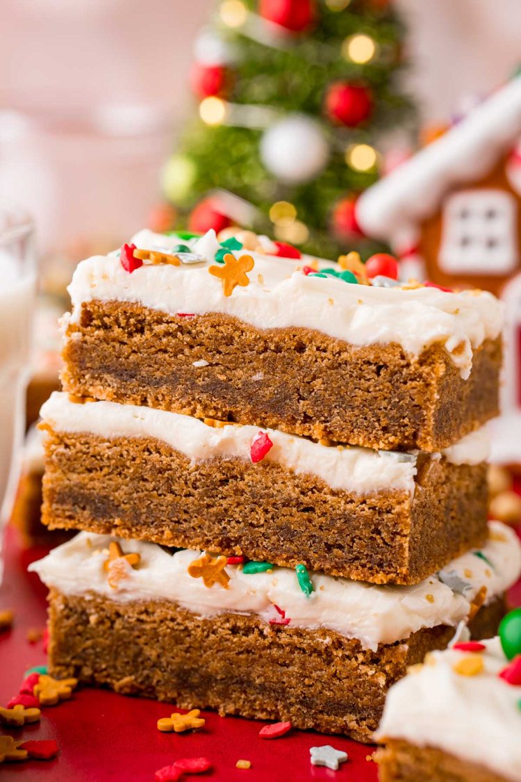 Close up photo of a stack of three gingerbread bars with cream cheese frosting.