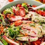 Close up photo of a grilled chicken salad with green goddess dressing.