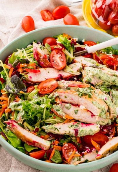 Close up photo of a grilled chicken salad with green goddess dressing.