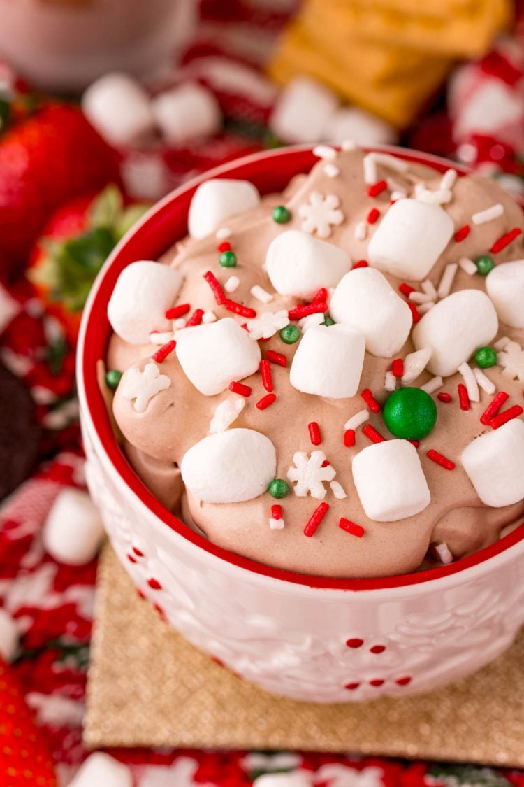Close up photo of a white and red holiday mug filled with hot chocolate dessert dip!