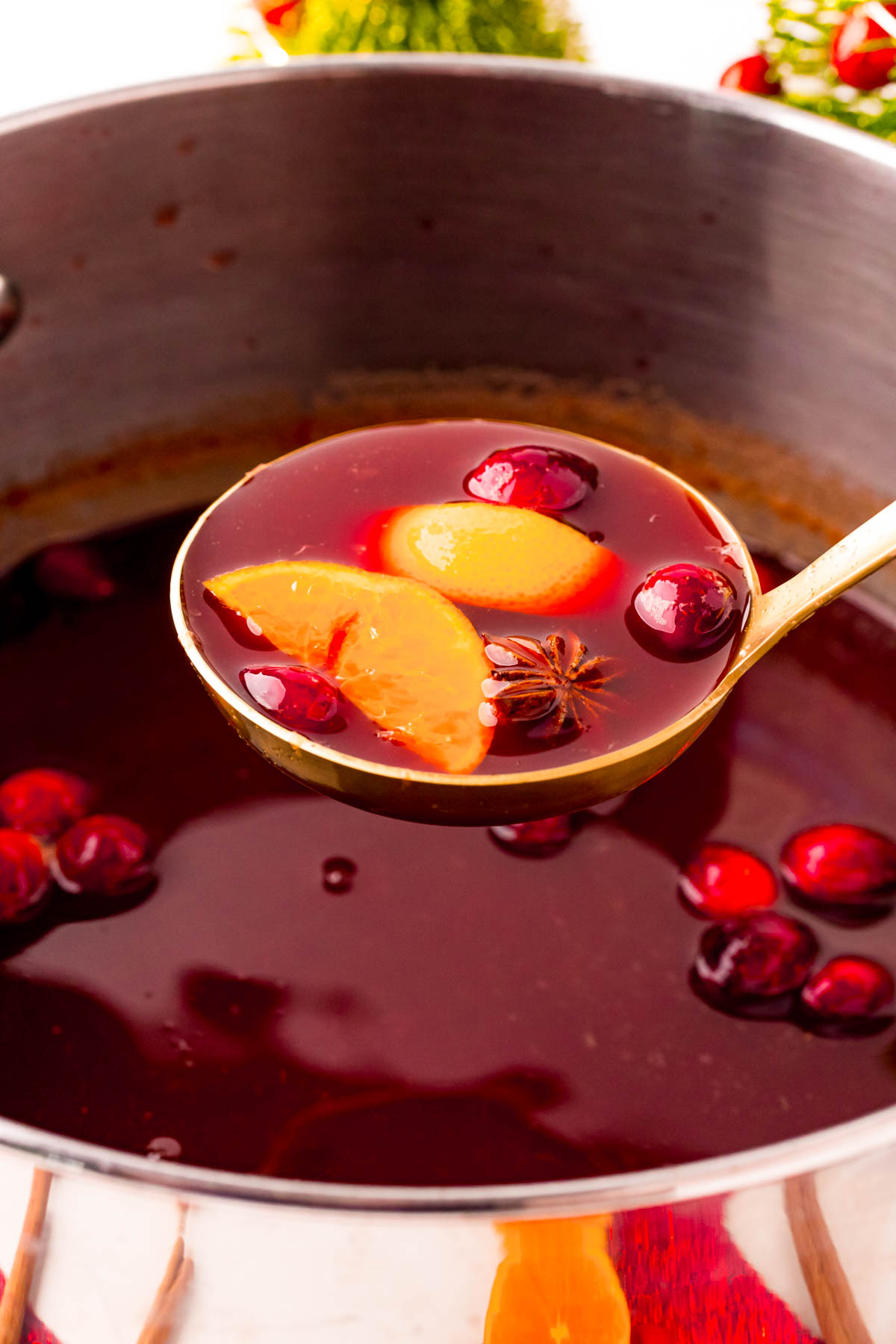 A ladle scooping German kinderpunsch (kinder punch) out of a large pot.