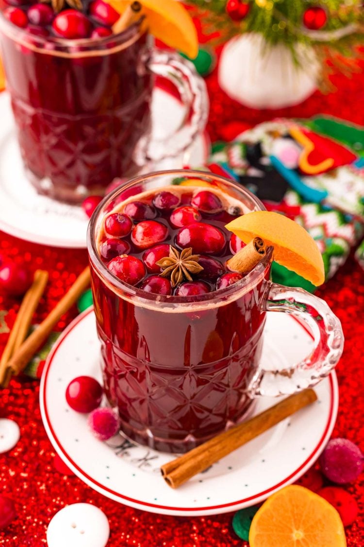 Kinderpunsch (kinder punch) in a mug on a white plate surrounded by holiday decorations.