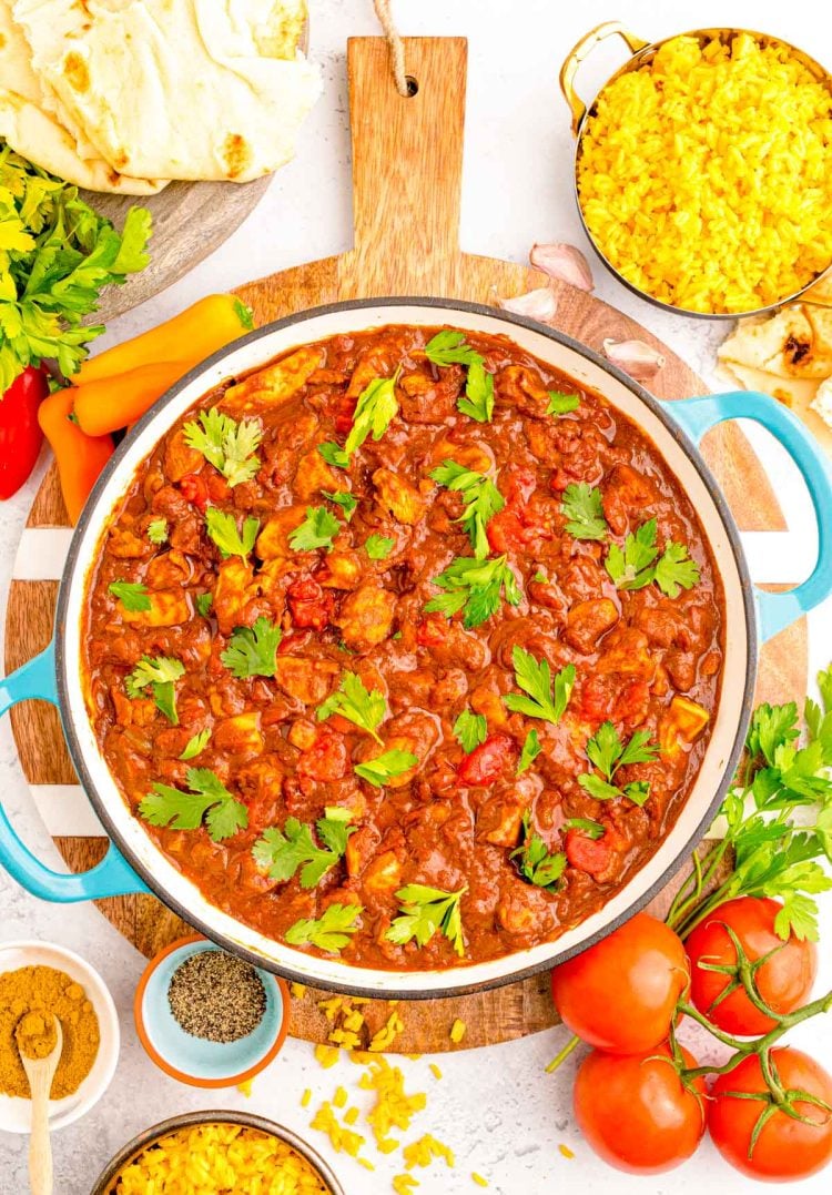 Overhead photo of a skillet with madras curry in it surrounded by ingredients.