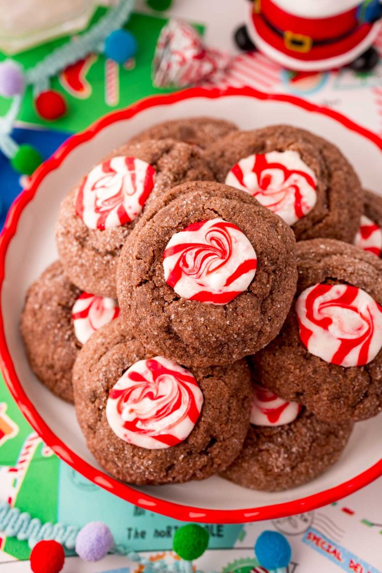 Close up photo of chocolate peppermint cookies on a red trimmed plate.