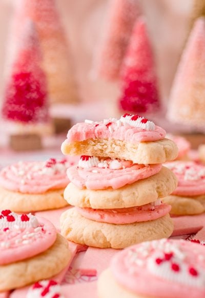Close up photo of a stack of 3 peppermint sugar cookies with the top cookie missing a bite.