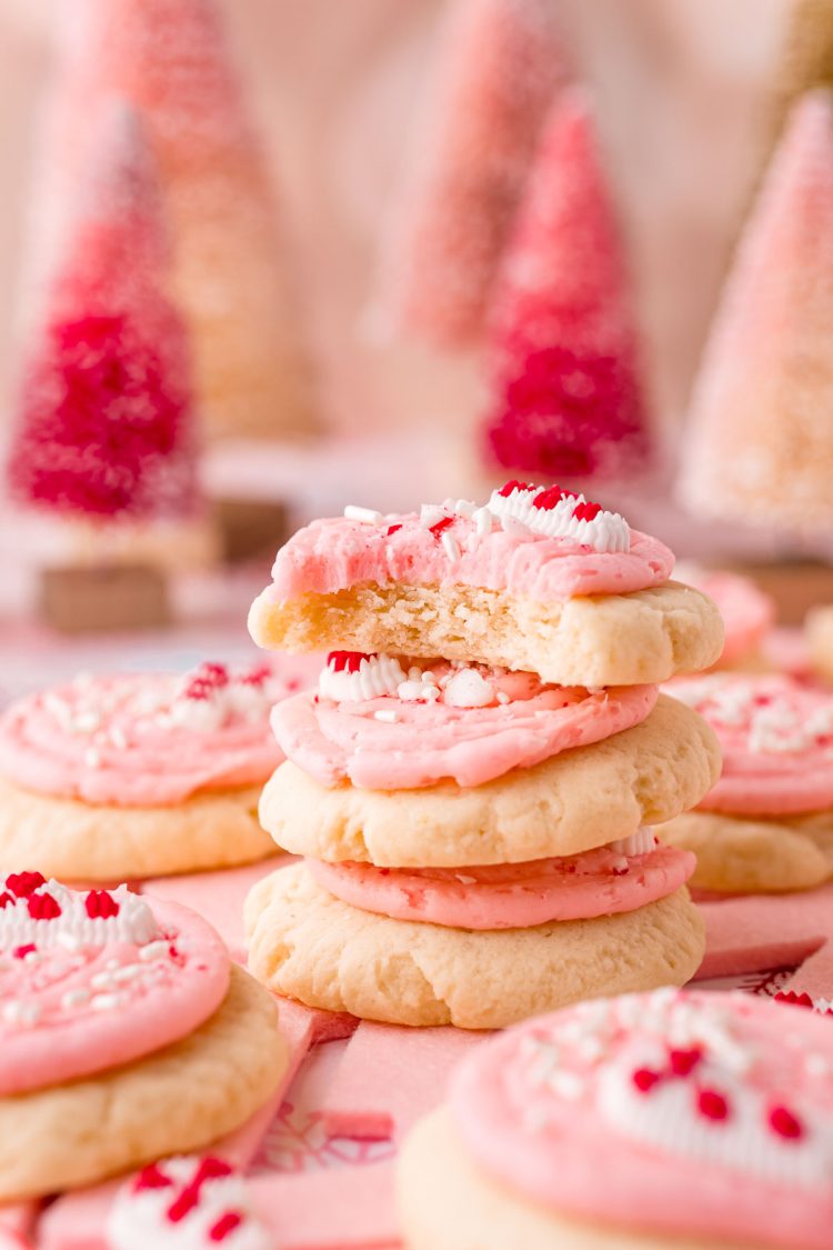 Close up photo of a stack of 3 peppermint sugar cookies with the top cookie missing a bite.