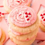 Close up photo of a stack of pink peppermint frosted sugar cookies.