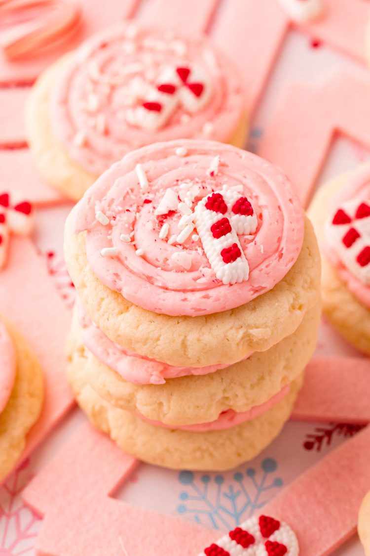 Close up photo of a stack of pink peppermint frosted sugar cookies.