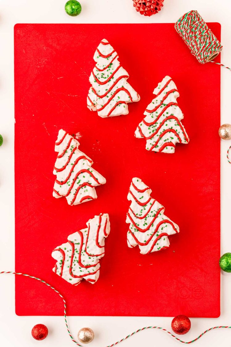 Overhead photo of Christmas tree cakes on a red cutting board.