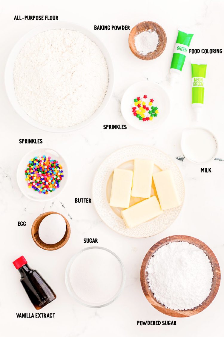 Overhead photo of ingredients prepped to make Christmas tree cookie stacks on a white marble surface.