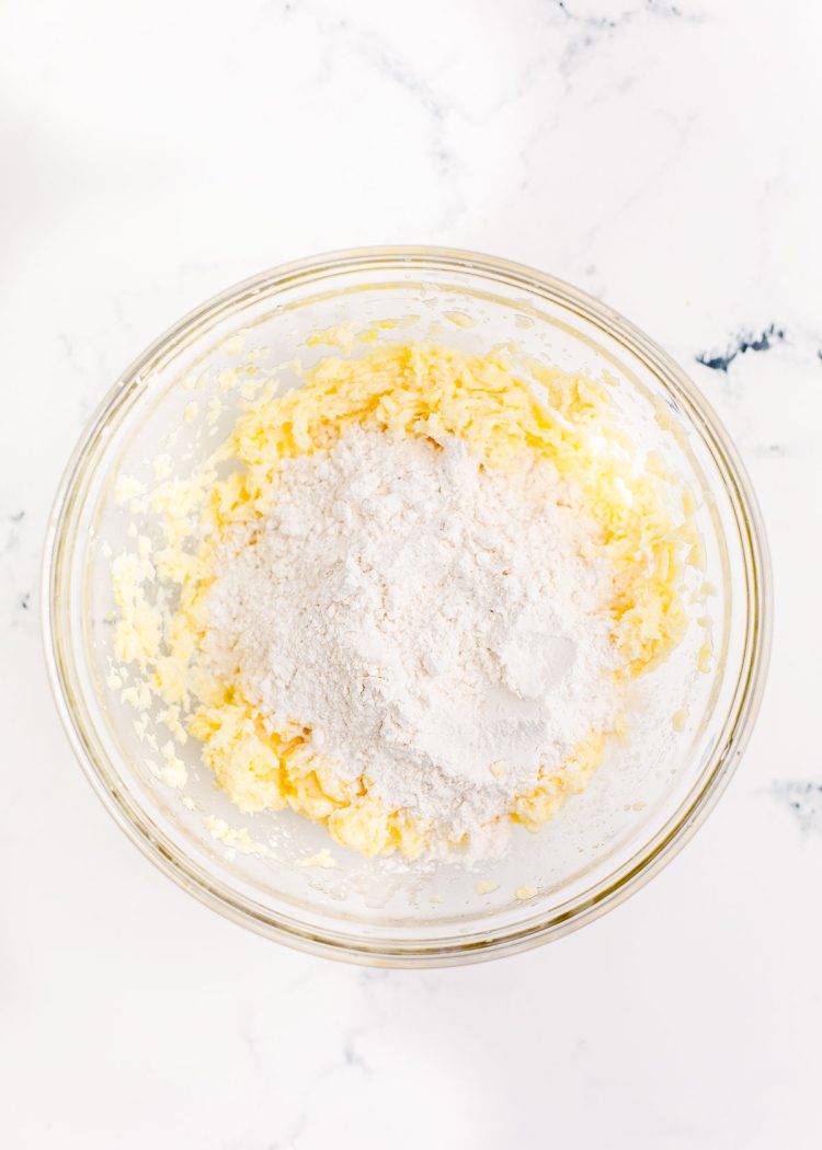 Overhead photo of a glass mixing bowl with ingredients to make sugar cookies in it.